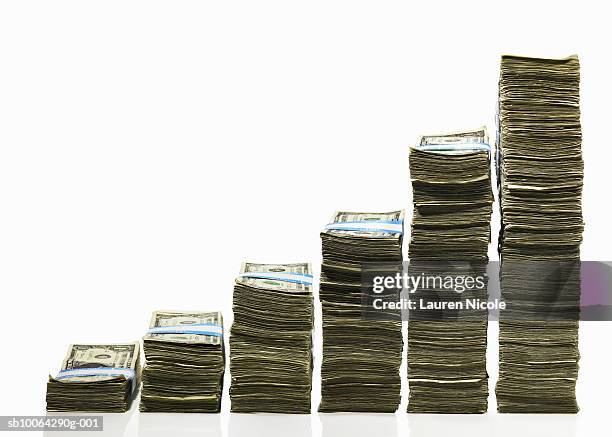 stacks of us currency in ascending graph pattern - stapeln stock-fotos und bilder