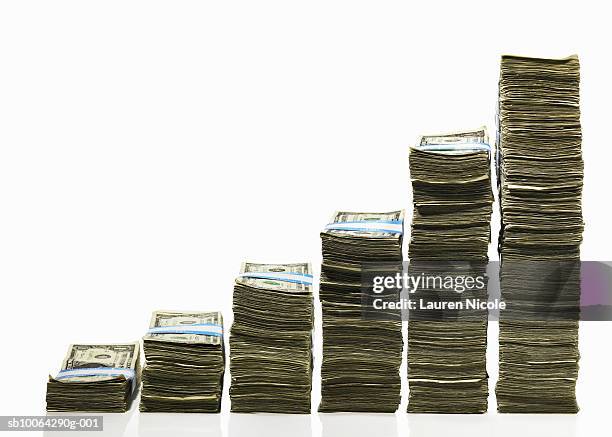 stacks of us currency in ascending graph pattern - montón fotografías e imágenes de stock