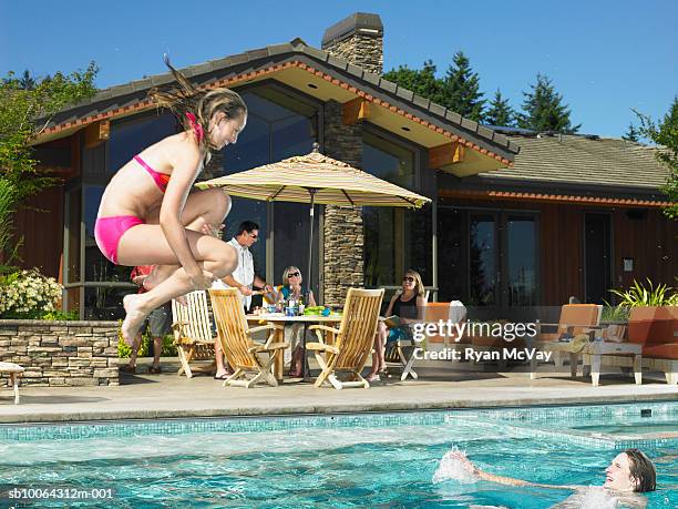 family by pool, woman jumping in pool - cannon ball pool stock pictures, royalty-free photos & images