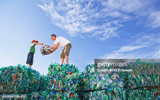 father and son (6-7) standing on block of recycling bottles, side view - day 6 fotografías e imágenes de stock