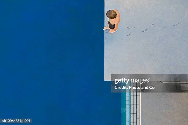 boy (6-7) standing on diving board, overhead view - challenging stock-fotos und bilder