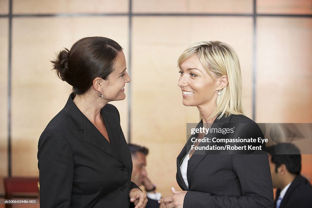 Two women talking during business meeting in hotel lobby