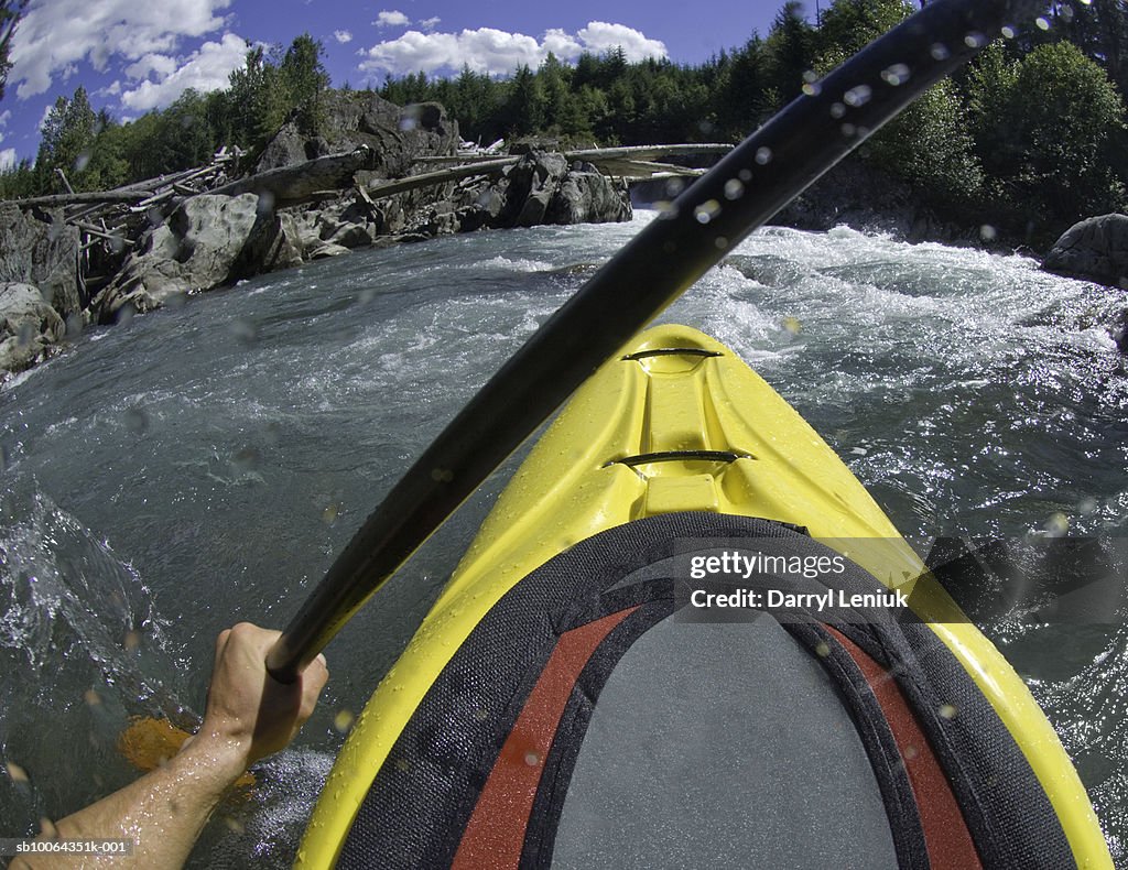 Whitewater kayaker paddling rapids in river