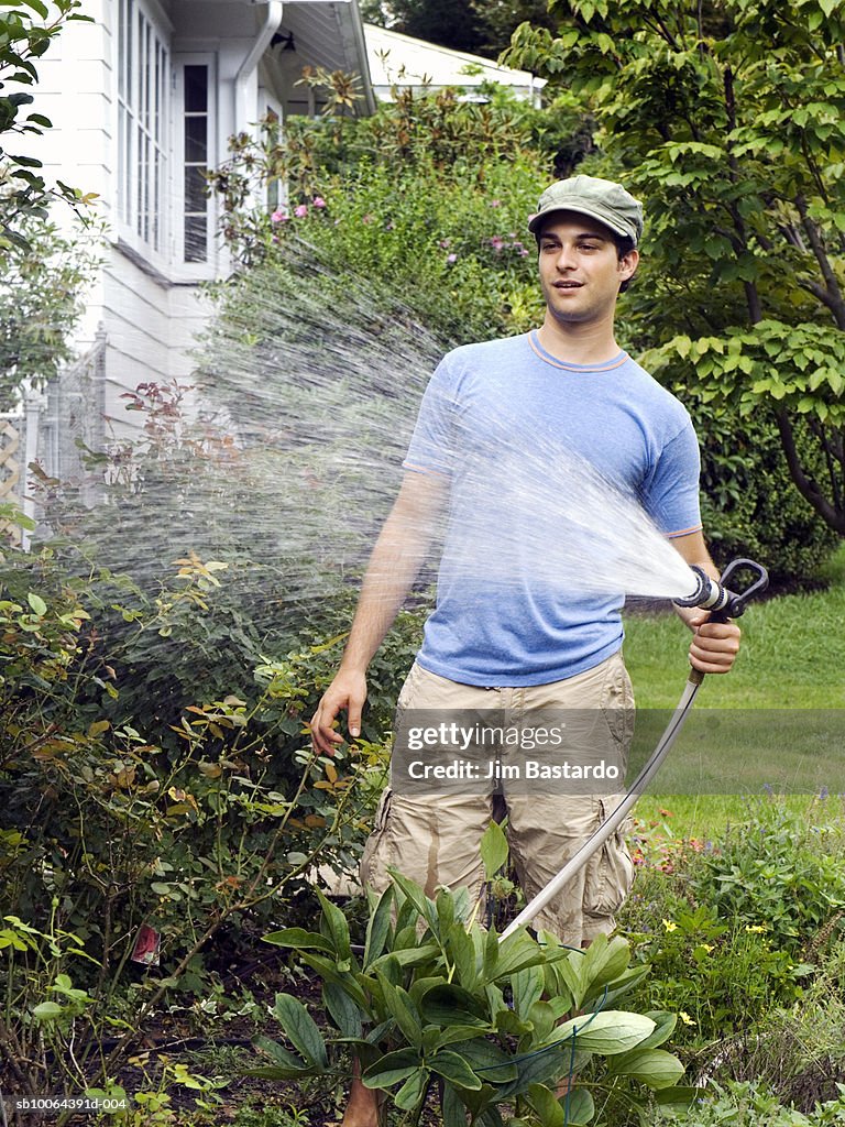 Young man watering plants