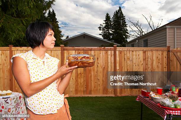 woman holding cake in tray, looking away - 2007 243 stock pictures, royalty-free photos & images