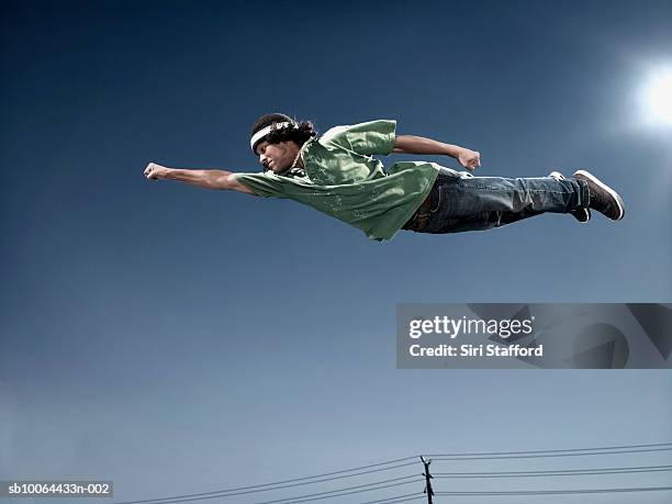 teenage boy (16-17) flying in mid air, low angle view - superhero flying stock pictures, royalty-free photos & images