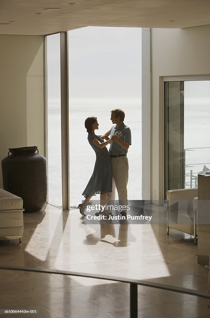 Young couple dancing in house