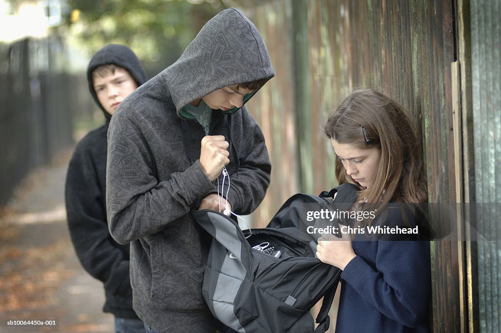 Two teenage boys (14-15) in hoods stealing items from school girl's bag (12-13)