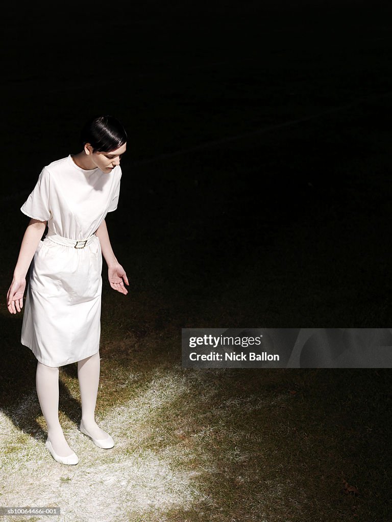 Young woman looking at spilled paint on ground