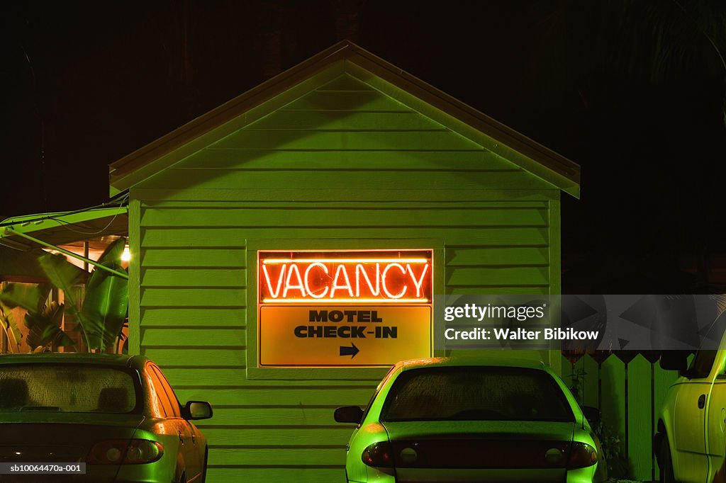 Motel with neon 'vacancy' sign, night