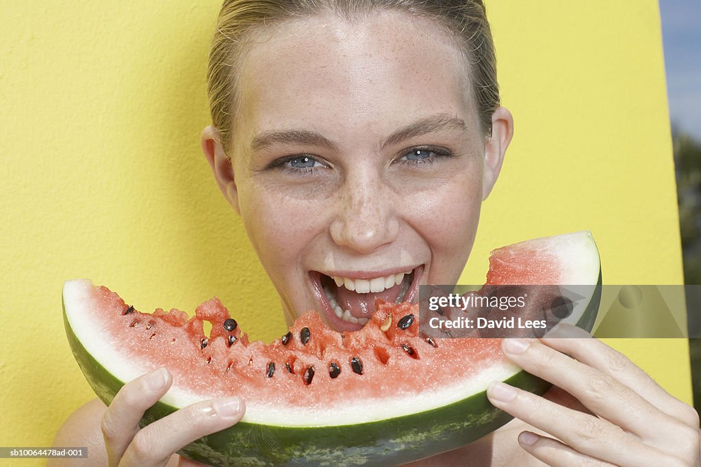 Teenage girl (14-15) eating watermelon, outdoors, portrait