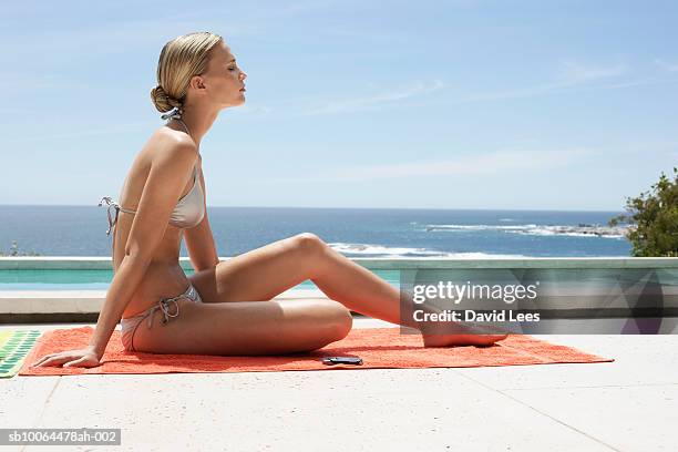 young woman in bikini relaxing near swimming pool at ocean - women sunbathing pool - fotografias e filmes do acervo