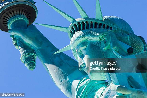 usa, new york, statue of liberty against blue sky, low angle view - statue of liberty new york city - fotografias e filmes do acervo