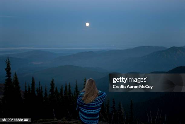 woman wrapped in blanket looking at landscape with full moon, rear view - full moon stock pictures, royalty-free photos & images