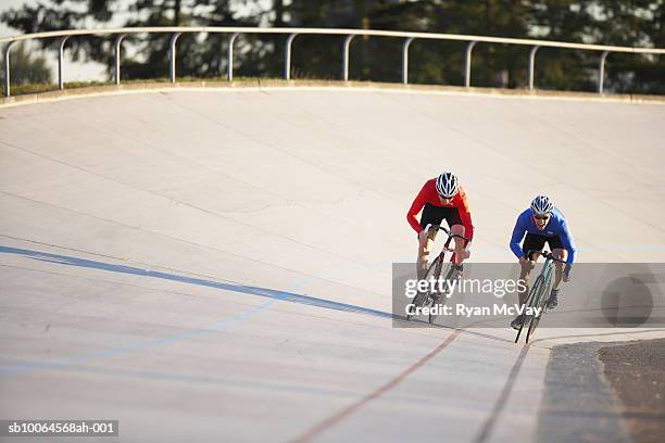 two cyclists racing on velodrome - track cycling stock-fotos und bilder