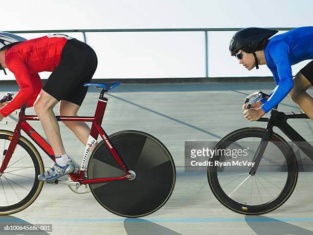 two cyclists in action on velodrome track, side view - track cycling stock pictures, royalty-free photos & images