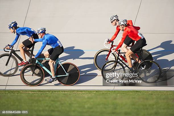cyclists racing on velodrome track - track cycling stock pictures, royalty-free photos & images