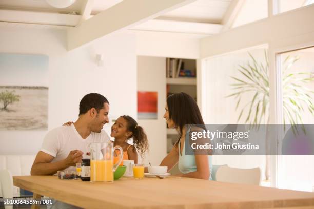 parents with daughter (6-7) at table having breakfast, smiling - mesa de jantar - fotografias e filmes do acervo