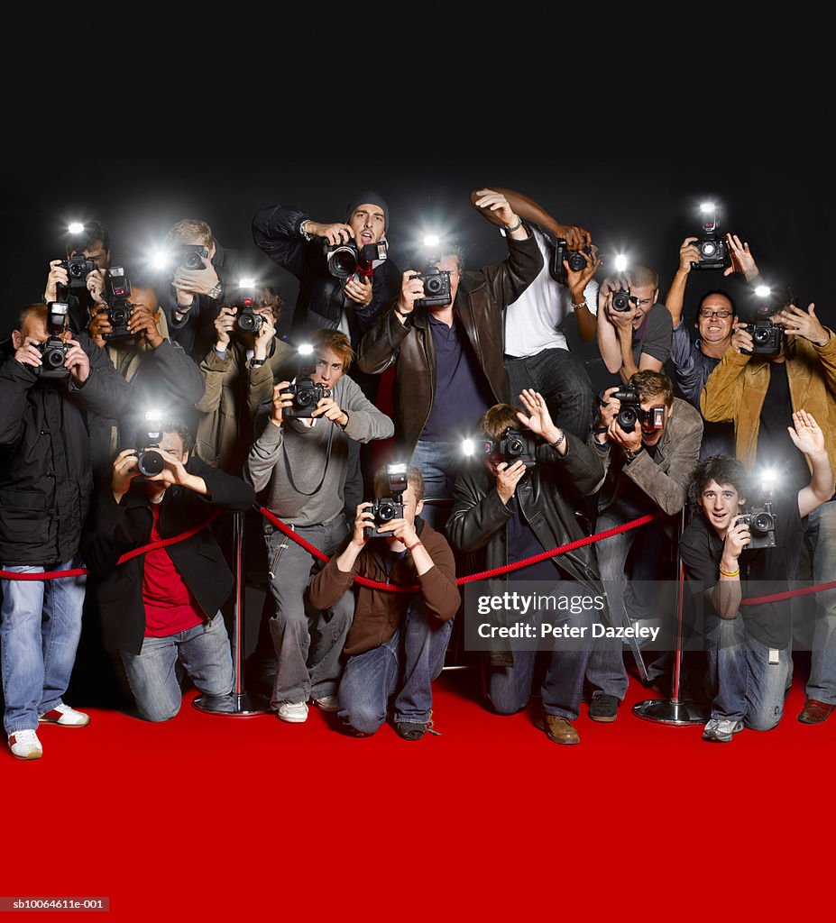 Paparazzi behind cordon at premiere using flash cameras