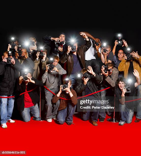 paparazzi behind cordon at premiere using flash cameras - fotógrafos imagens e fotografias de stock