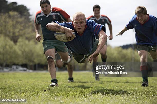 rugby player scoring jumping on groud with ball - try rugby stock-fotos und bilder