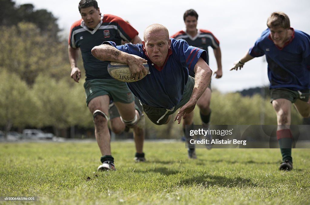 Rugby player scoring jumping on groud with ball