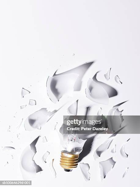 smashed light bulb on white background - exploding lightbulb stock pictures, royalty-free photos & images