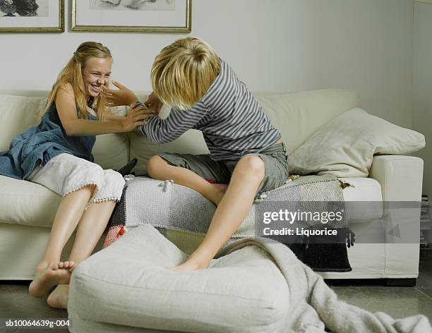 brother and sister (10-14) fighting on sofa - girls wrestling stock pictures, royalty-free photos & images