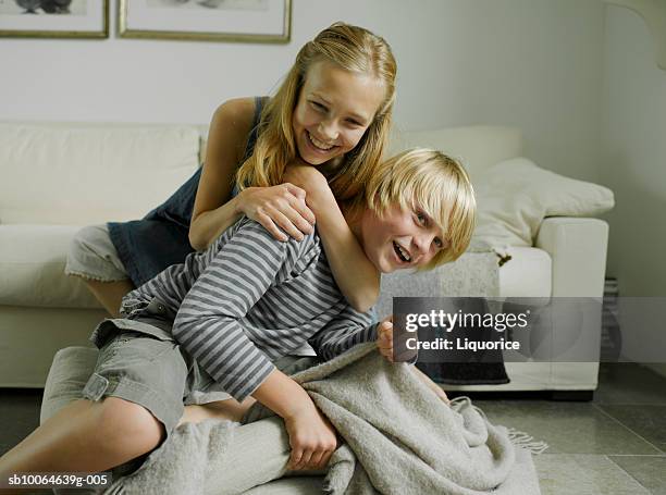 brother and sister (10-14) fighting on sofa - girl wrestling fotografías e imágenes de stock