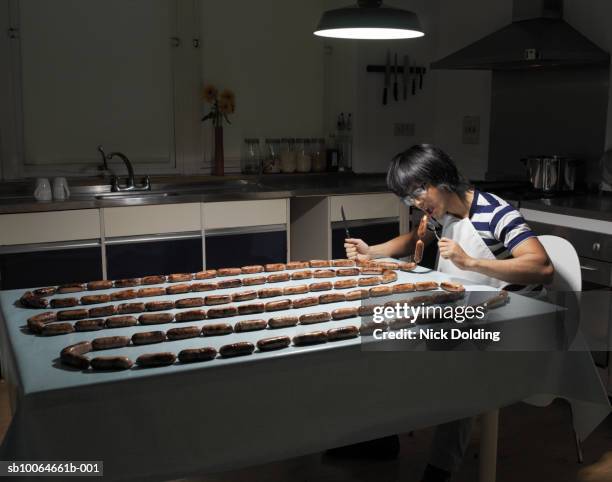 man sitting at table eating hot dogs, - asian eating hotdog stock pictures, royalty-free photos & images