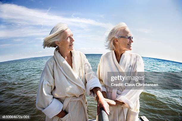 two senior women in bathrobes against sea - fisheye stock pictures, royalty-free photos & images