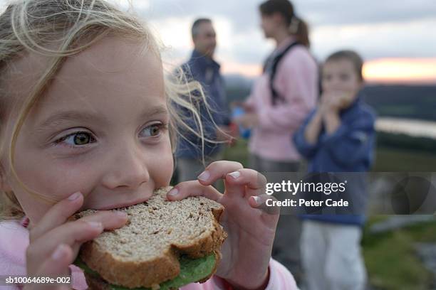 family with children (6-8) eating sandwiches on moors, focus on girl in foreground - sandwich stock-fotos und bilder