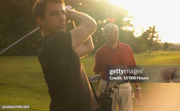 two men playing golf, looking away - senior men golf stock pictures, royalty-free photos & images