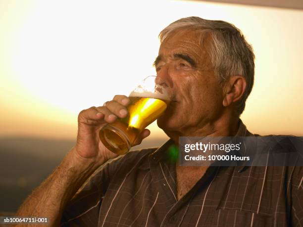 senior man drinking beer outdoors - senior men beer stock pictures, royalty-free photos & images