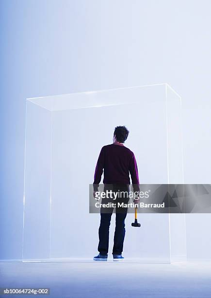 young man holding hammer on glass cabinet, rear view - stuck indoors stock pictures, royalty-free photos & images