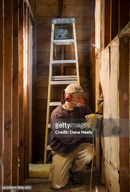 construction worker installing insulation in house - tacler stock-fotos und bilder