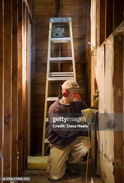 construction worker installing insulation in house - house insulation not posing stockfoto's en -beelden