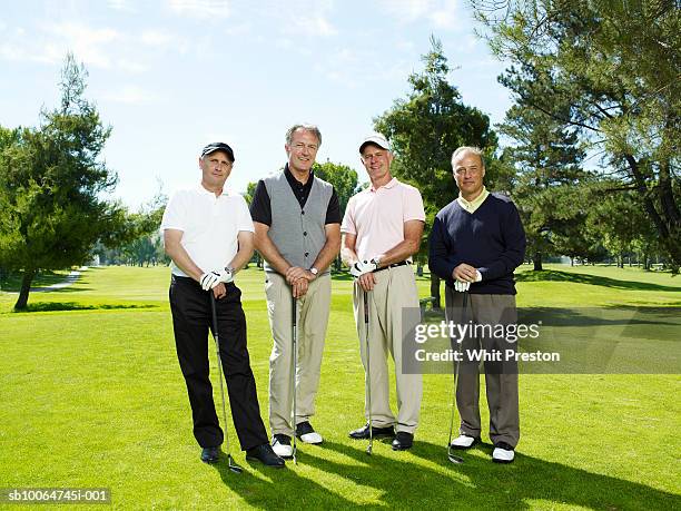 group portrait of male golfers leaning on clubs - four people stock pictures, royalty-free photos & images