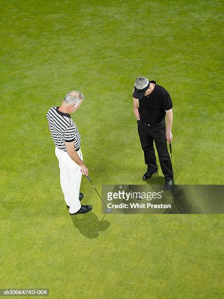 two male golfers looking at ball and hole, elevated view - golf short iron stock pictures, royalty-free photos & images