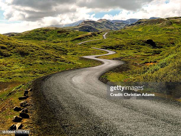 country road passing through mountains - iceland mountains stock pictures, royalty-free photos & images