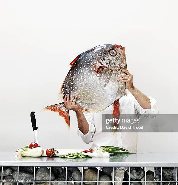 chef holding big fish in commercial kitchen, obscured face, studio shot - big cook 個照片及圖片檔