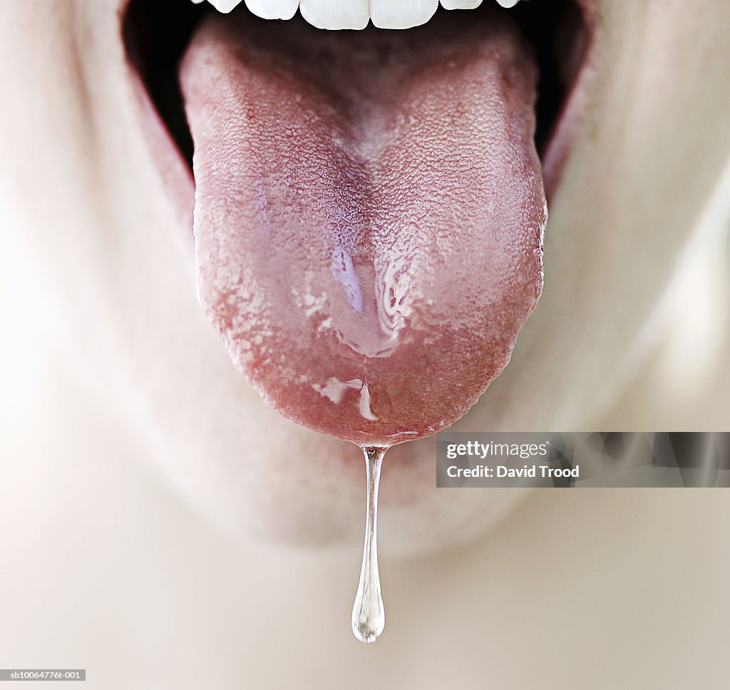 Woman's tongue dripping with saliva, close-up