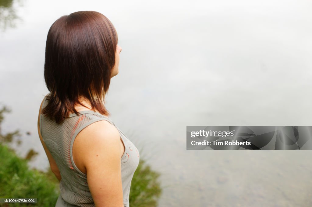 Woman looking out across water, elevated view