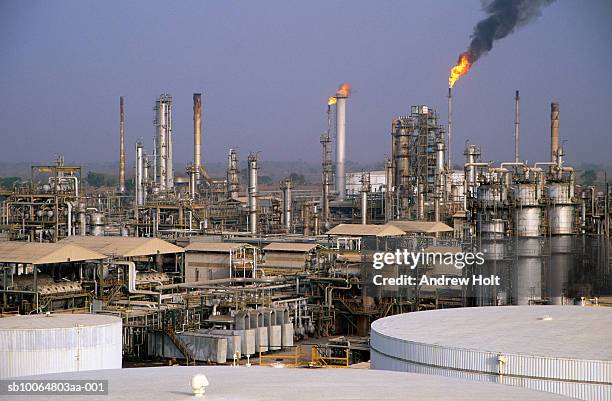 flare stack burning waste gas at oil refinery - refinery stock pictures, royalty-free photos & images