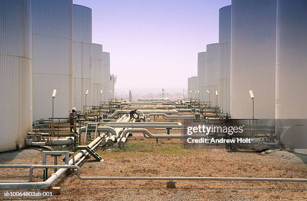 two men working at oil storage tank - west africa stock pictures, royalty-free photos & images