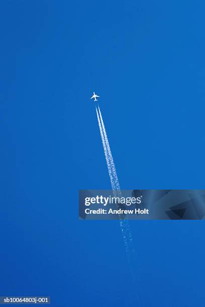 aeroplane leaving vapour trail in clear blue sky, low angle view - low flying aircraft stockfoto's en -beelden