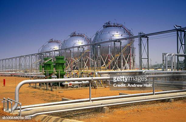 oil storage tank with feed pipes leading to power station boilers - nigeria oil stock pictures, royalty-free photos & images