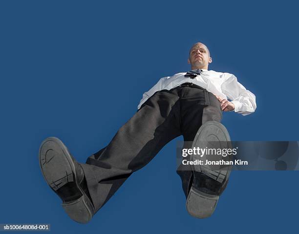 mid adult business man standing on glass, blue sky, view from below - low angle view man stock pictures, royalty-free photos & images