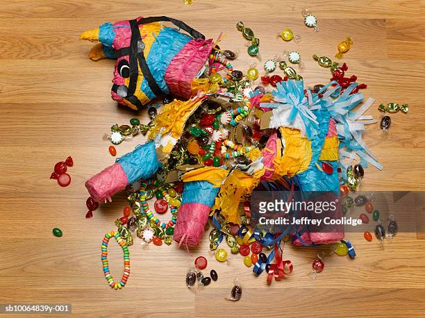 smashed donkey pinata on floor with candy - piñata fotografías e imágenes de stock