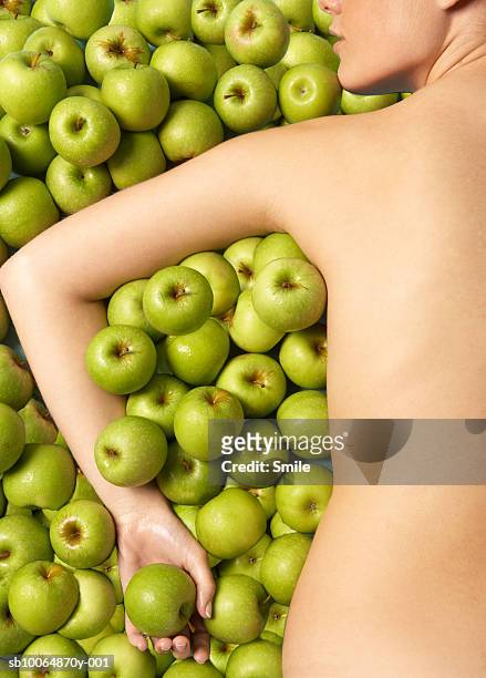 naked woman lying in apples, rear view - young women no clothes stock pictures, royalty-free photos & images